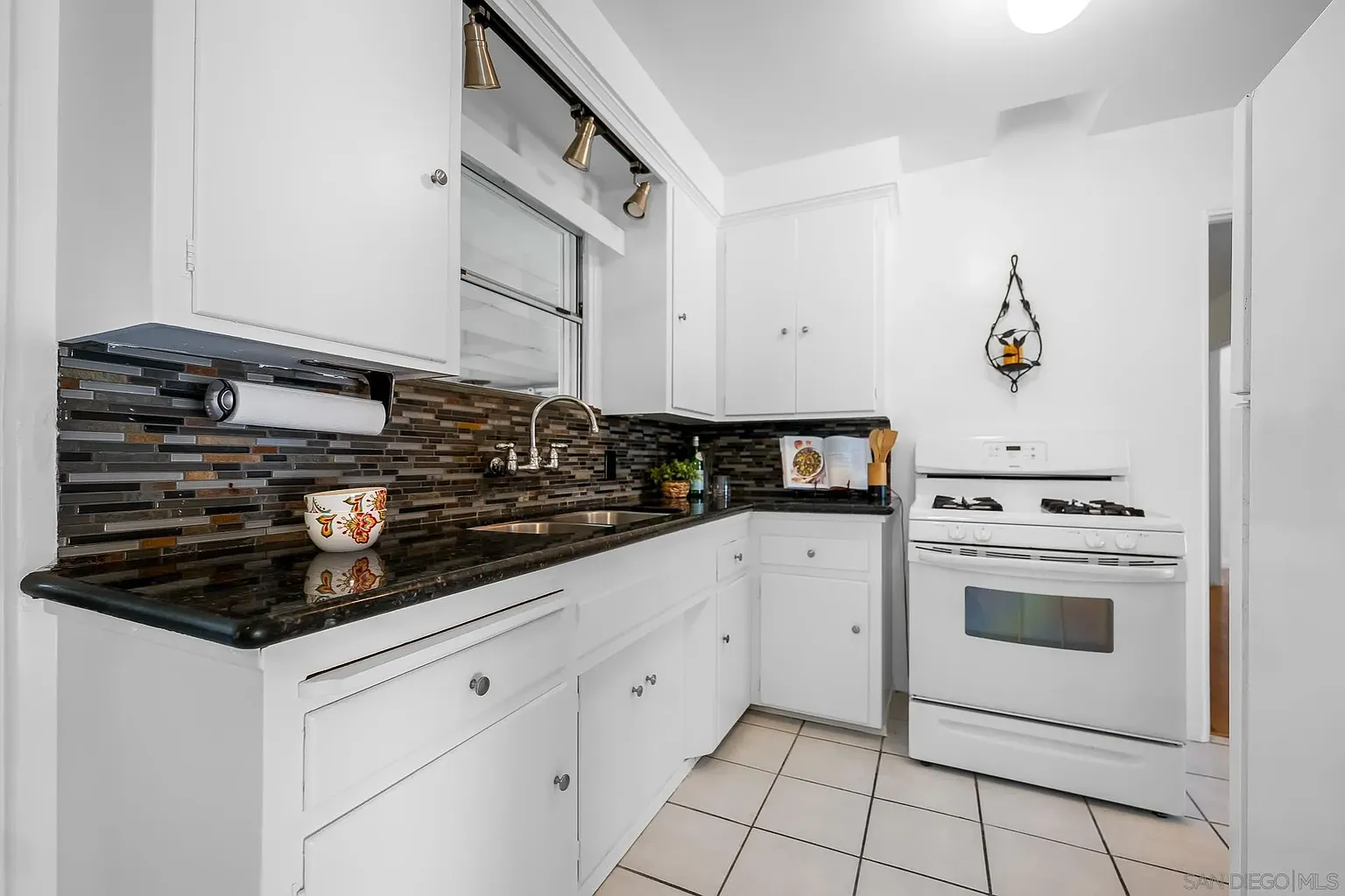 Vintage Kitchen Styled with Black Stone Backsplash and Bright Whites