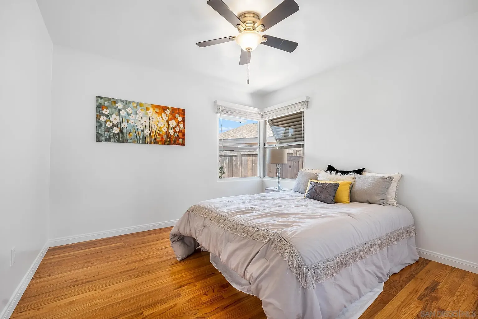 Guest Bedroom with Warm Wood Floors and Layered Textiles